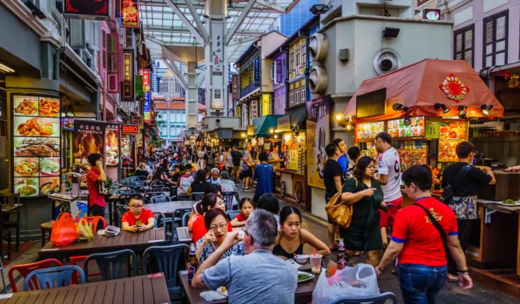 Vibrant Singapore nightlife with illuminated skyline, bustling streets, and people enjoying local food and shopping